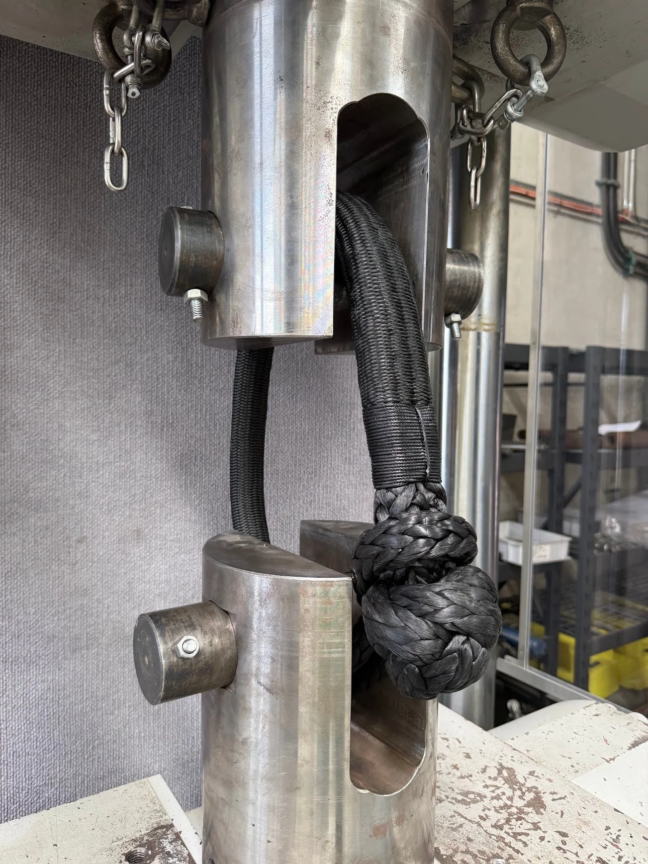 Close-up of a soft shackle knot clamped into steel test-rig jaws during a destructive breaking-strength test